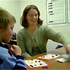 A student tutors a boy using flash cards